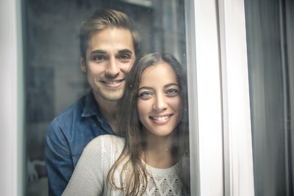 Cheerful couple looking out of the window, furnace pressure switches